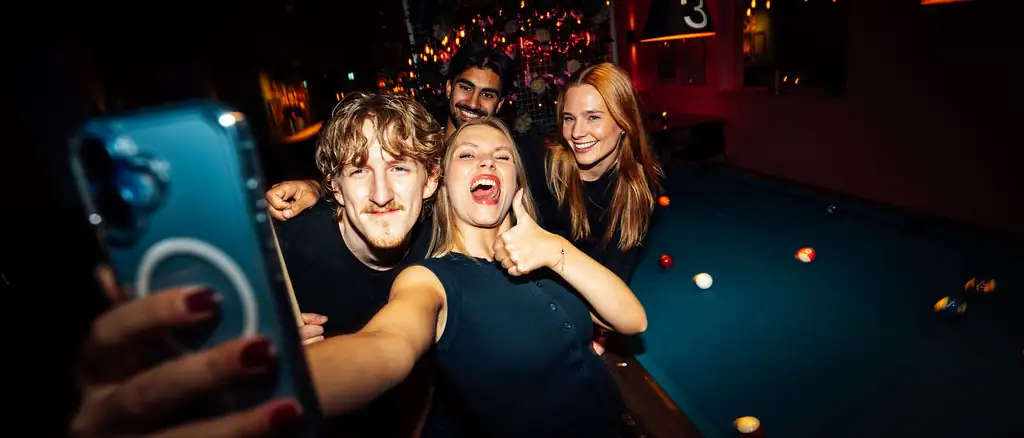 Kolleger tar selfie ved biljardbordet under et firmaevent hos Oslo Bar & Bowling