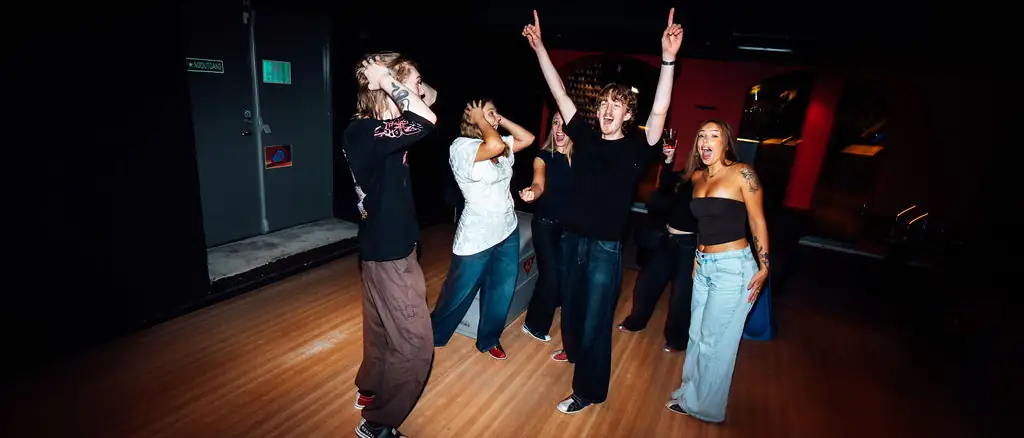 Studenter som danser og feirer på bowlingbanen
